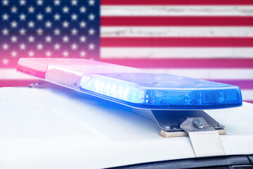 Police car with red and blue lights on a United States of America flag background. © gesrey