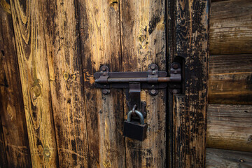 wooden door closed with an iron lock. Wooden wall
