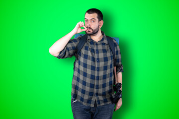 Portrait of serious male dressed trendy in black and white shirt. Isolated shot of stylish man shows silence sign. People concept