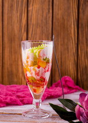 milk fruit dessert souffle mousse with pieces of jelly in a beautiful glass on a leg on a white background
ice cream in a beautiful glass but on a wooden background