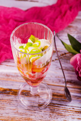 milk fruit dessert souffle mousse with pieces of jelly in a beautiful glass on a leg on a white background
ice cream in a beautiful glass but on a wooden background