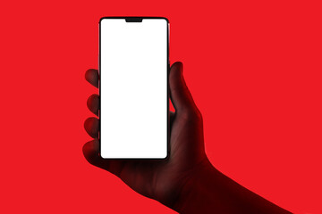 Hand holding phone. Silhouette of male hand holding smartphone isolated on red background....