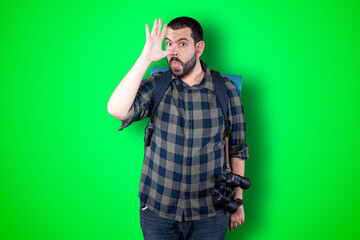 Emotional portrait of a bearded shocked man, amazed funny expression isolated on green background