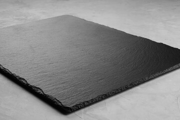 Slate Board on a grey background for product placement on the diagonal. Close up.