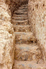 Staircase, carved in clay crag. Steep climb up srairs carved in cliff of loamy soil.