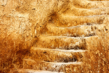 Close up of saircase, carved in clay crag. Steep climb up srairs carved in cliff of loamy soil.
