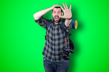 Portrait of a cheerful young traveler man showing okay and victory gesture isolated on the chroma background