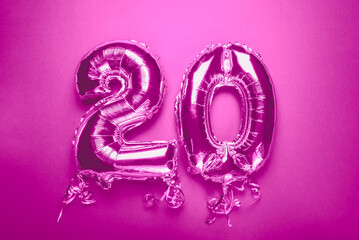 Silver Number Balloon 20 on pink background. Holiday Party Decoration or postcard concept with top view on pink background