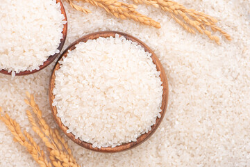 Raw rice in a bowl and full frame in the white background table, top view overhead shot, close up