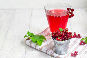 Red currants on a light wooden background. Vitamin cocktail.