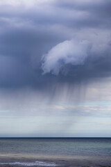 Naklejka na ściany i meble rain clouds hanging over the sea