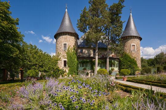 Les Crots, Hautes-Alpes, 05200, France - August 23, 2019: Picomtal Castle (Historic Monument) with its two towers and summer garden in bloom. Provence-Alpes-Cote d'Azur Region