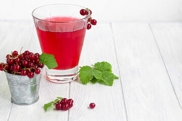 Red currants on a light wooden background. Vitamin cocktail.