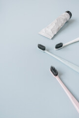 Toothbrushes, toothpaste on blue background. Flat lay, top view oral care, dental hygiene concept.