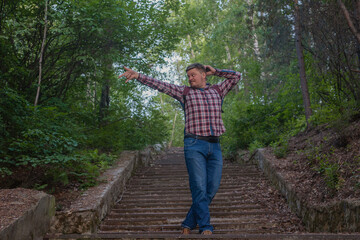  the man climbed the stairs to the very top. A man on an abandoned stone staircase in the forest