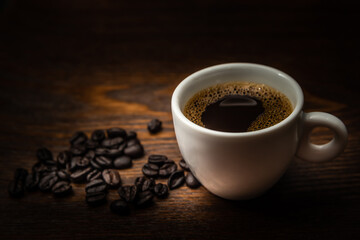 Xícara branca com café sobre a mesa.