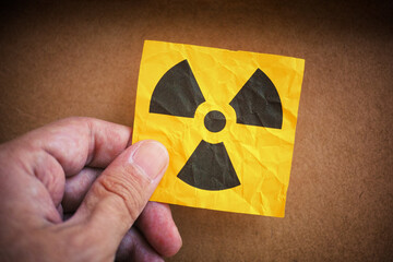 Fototapeta premium Man holding radiation warning sign in his hand