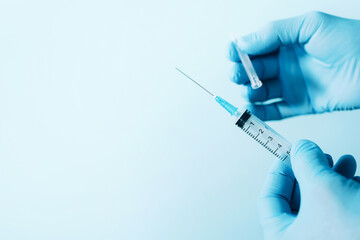 Hand in medical gloves holding syringe on blue background. Copy space. Injections and vaccination...