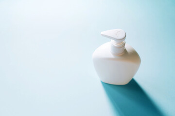 White soap bottle on blue background. Copy space. Close up of beauty hygiene container with clipping path. Products to stay safe during pandemic covid19 quarantine.