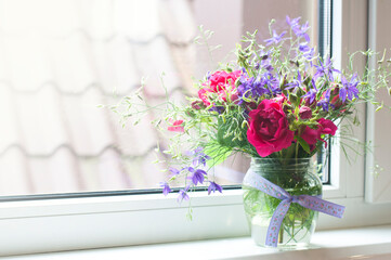 Bouquet of flowers in a vase on the windowsill. Spring and summer flowers