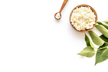 Cottage cheese in wooden bowl on white table top view copy space