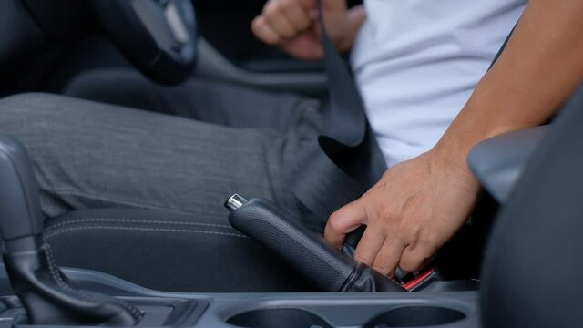 The man driver wears a seat belt in the car before driving.