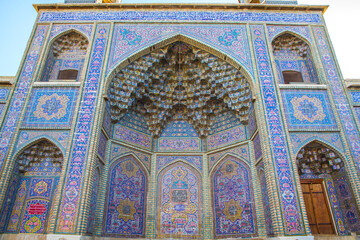 Famous pink mosque decorated with mosaic tiles and religious calligraphic scripts from Persian Islamic Quran, Shiraz, Iran. 