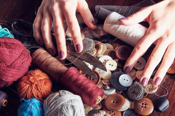 Woman tailor using retro sewing machine at home, hobby concept.