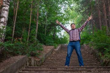  the man climbed the stairs to the very top. A man on an abandoned stone staircase in the forest