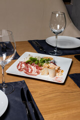 Slicing of fat, lard and bacon on a white plate on a served wooden table. Pork, meat.