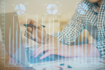 Multi exposure of forex graph with man working on computer on background. Concept of market...