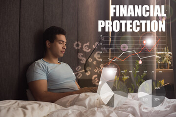 handsome mixed race freelancer using laptop near financial protection lettering, money signs, charts and graphs