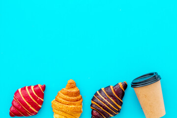 Set of coffee with croissants - chocolate, berry, classic - on blue stone table