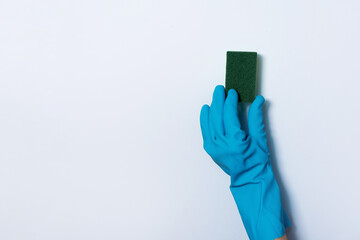 Hand in glove holding microfiber cleaning cloth, sponge on white background. Copy space. Cleaning service concept. Spring general or regular clean up. Commercial cleaning company concept.