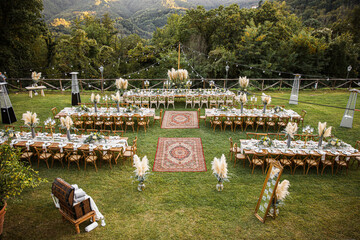 Fototapeta na wymiar Wedding table set up in boho style with pampas grass and greenery