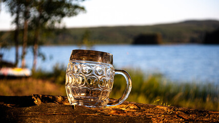 The midnight sun shines on an empty beer jug. Photo was taken on midsummer's day next to the lake...