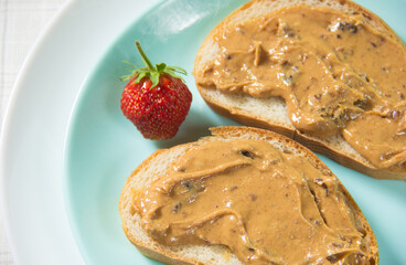 Two peanut butter sandwiches in close-up. The peanut butter sandwich is on the plate