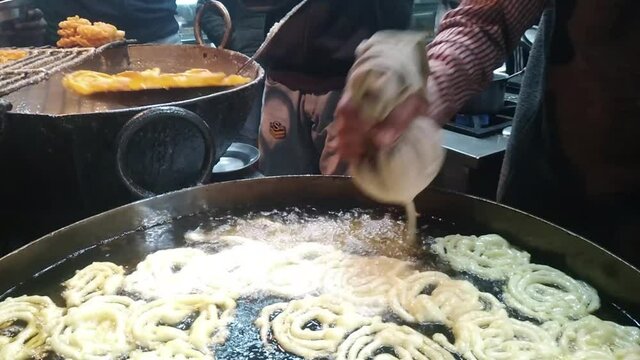 Indian sweetness of jeleby is fried in the street in deep-fried