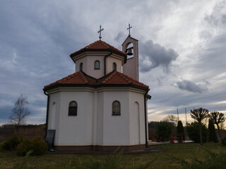Fototapeta na wymiar Church in the countryside against overcast sky during evening.