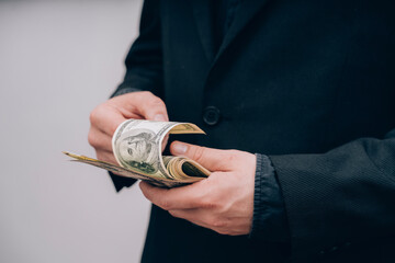 man in black counts dollars in hands
