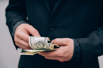 man in black counts dollars in hands
