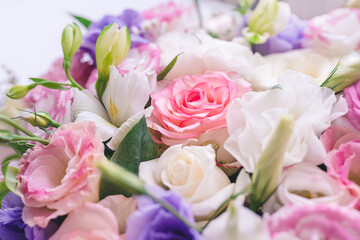 Fototapeta na wymiar beautiful bouquet of colorful flowers: roses, eustomas, lilies close-up
