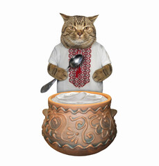The beige cat patriot in a ukrainian traditional shirt with a spoon is eating sour cream from a clay pot. White background. Isolated.