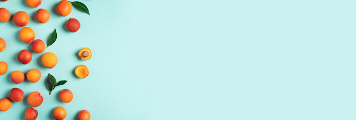 Apricot pattern on blue background. Top view, flat lay. Fresh summer fruit concept. Creative design. Healthy vegetarian food, detox or diet concept.