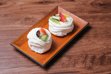 Woman's hands in the kitchen making mini pavlovas