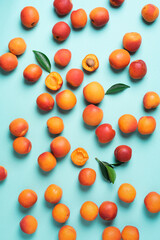 Apricot pattern on blue background. Top view, flat lay. Fresh summer fruit concept. Creative design. Healthy vegetarian food, detox or diet concept.