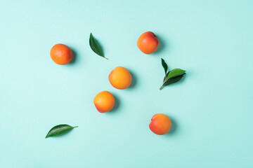 Apricot pattern on blue background. Top view, flat lay. Fresh summer fruit concept. Creative design. Healthy vegetarian food, detox or diet concept.