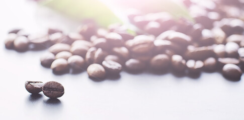 Coffee beans with green leaves for cooking. Bag of coffee. Coffee beans roasted on the table.