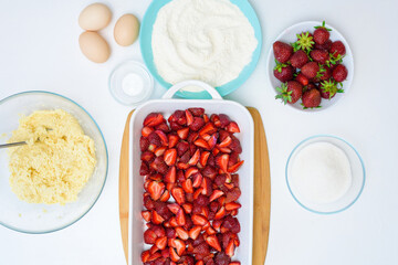 step by step recipe strawberry cobbler homemade from ripe fresh strawberries and shortbread on a light background, top view. cut the strawberries and mix with the starch, lay out the dough
