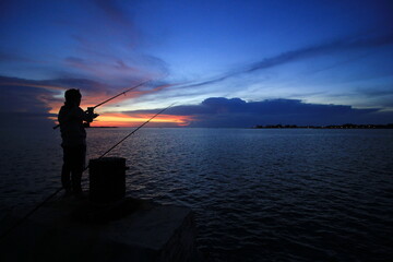 The silhouette of fishing at sunset